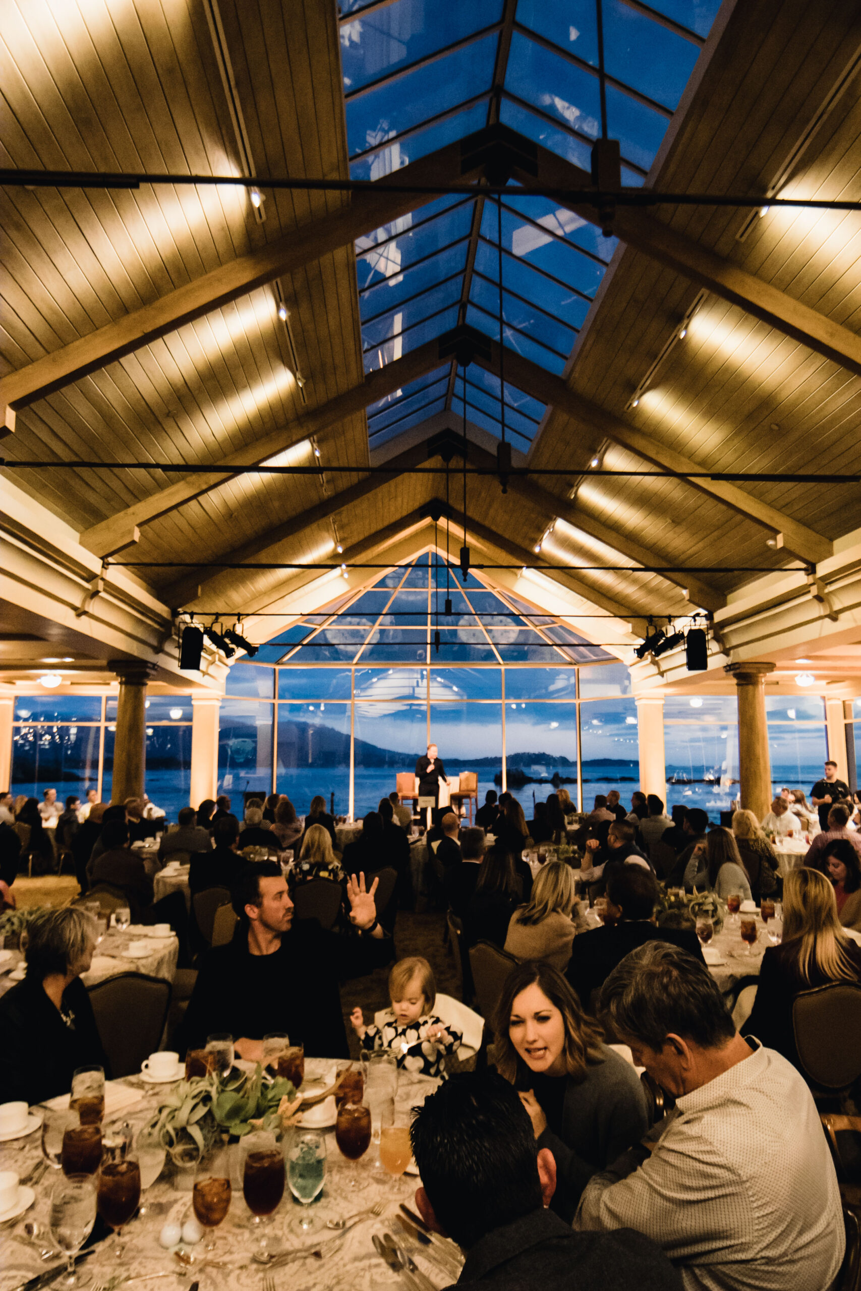 People seated at a table in a large room at a corporate event