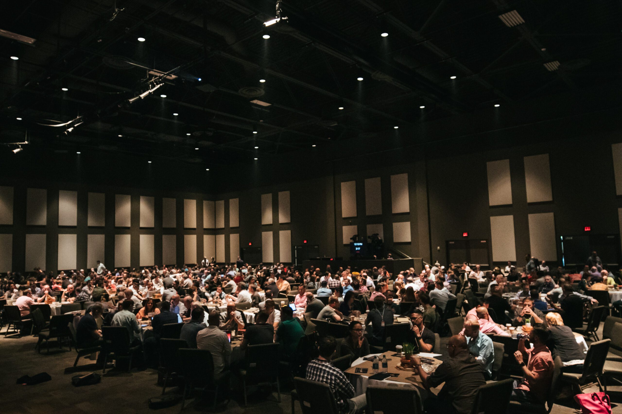 Large room filled with lots of people sitting at tables