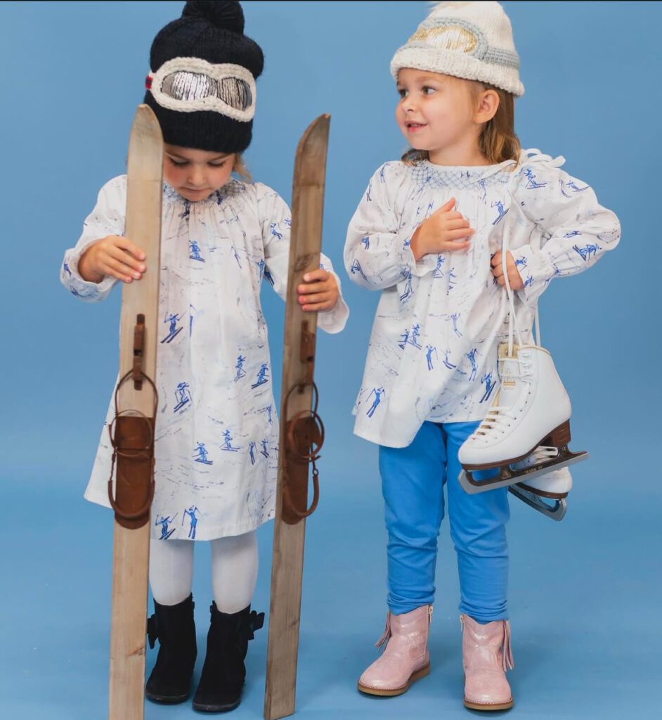 Two children dressed in Elephantito Branded boots with skis